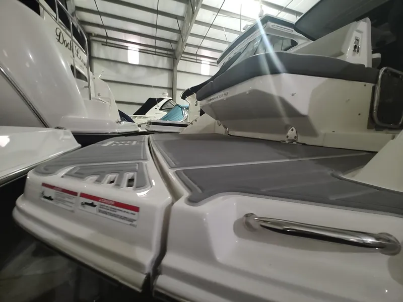 Slide: The Image of 2023 Sea Ray 320 Sundancer in a showroom, showcasing the rear deck and swim platform. - 31