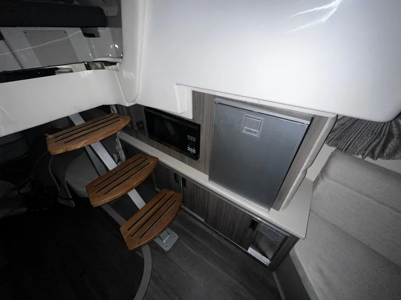 Slide: The Image of Interior of 2023 Sea Ray 320 Sundancer with wooden steps, microwave, and mini-fridge. - 38