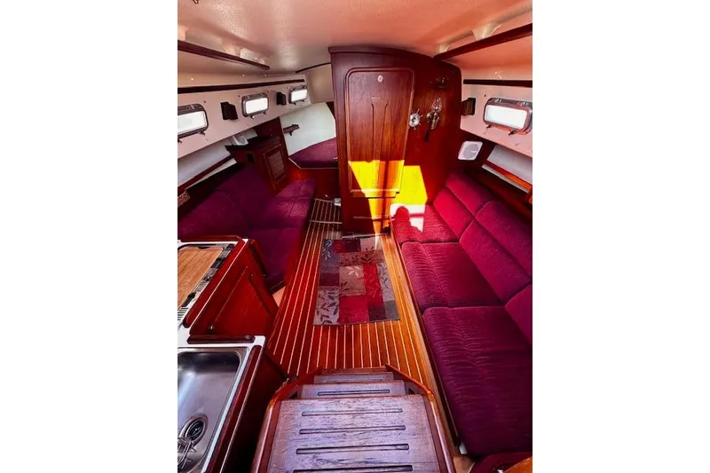 Slide: The Image of Interior of 1987 Island Packet 27 sailboat with red upholstery and wooden finishes. - 15
