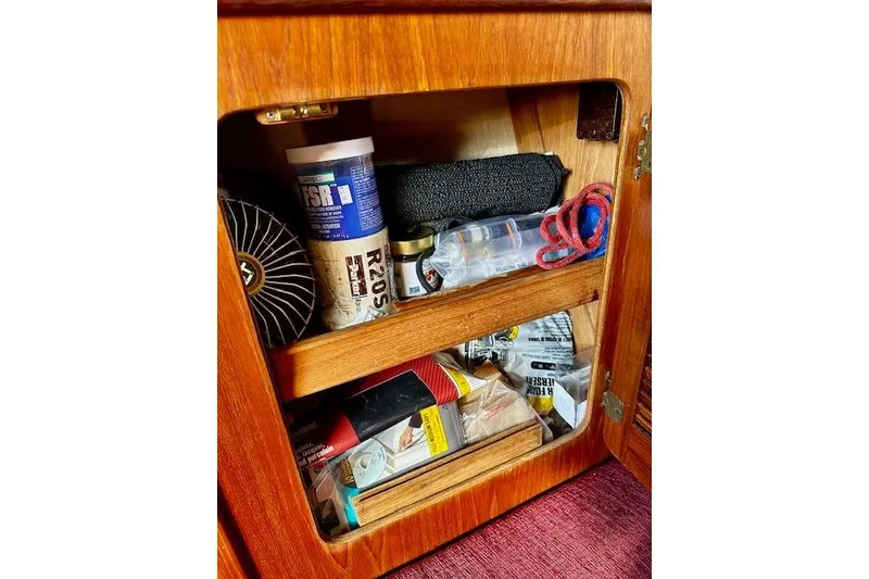 Slide: The Image of Storage cabinet on 1987 Island Packet 27 sailboat with various maintenance supplies. - 16