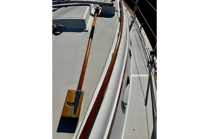 Slide: The Image of 1987 Island Packet 27 sailboat deck with wooden handrail and tiller. - 19