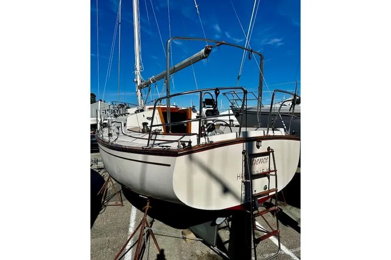 Slide: The Image of 1987 Island Packet 27 sailboat on land, showcasing stern and deck details. - 25