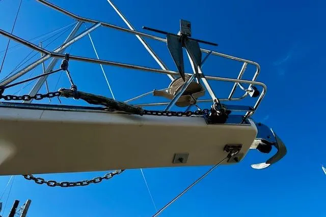 Slide: The Image of 1987 Island Packet 27 sailboat bow with anchor against clear blue sky. - 26