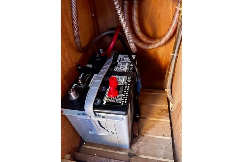 Slide: The Image of Battery compartment of a 1987 Island Packet 27 sailboat, showing wiring and connections. - 27