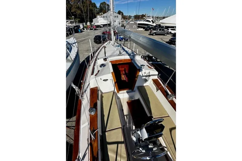 Slide: The Image of 1987 Island Packet 27 sailboat with wooden accents and beige seating in a marina. - 5