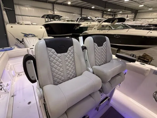 Slide: The Image of 2022 Sailfish 290cc boat interior with luxurious seating in a showroom. - 11