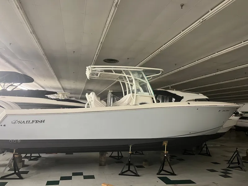 Slide: The Image of 2022 Sailfish 290cc boat displayed indoors on stands. - 7