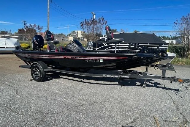 The Image of 2021 Ranger RT178 boat on trailer, parked outdoors under clear blue sky. - 1