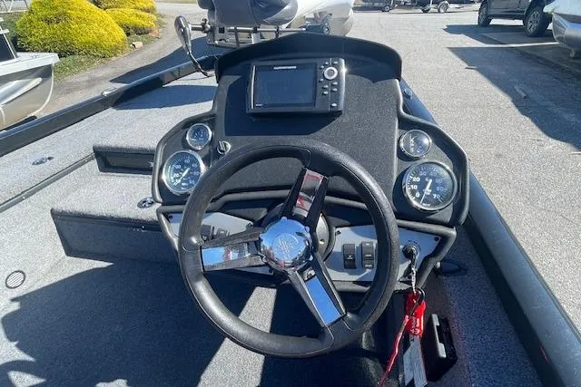 Slide: The Image of 2021 Ranger RT178 boat dashboard with steering wheel and gauges in a parking lot. - 7
