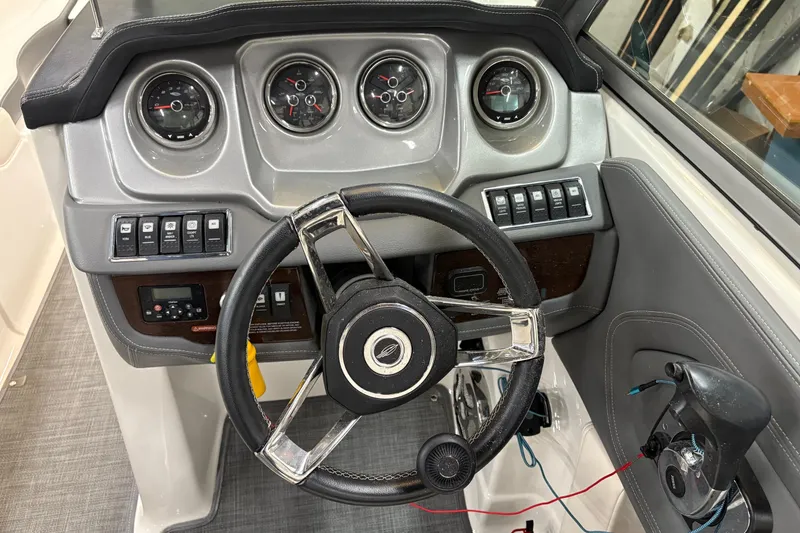 Slide: The Image of 2015 Chaparral 244 Sunesta boat interior with steering console and seating. - 13