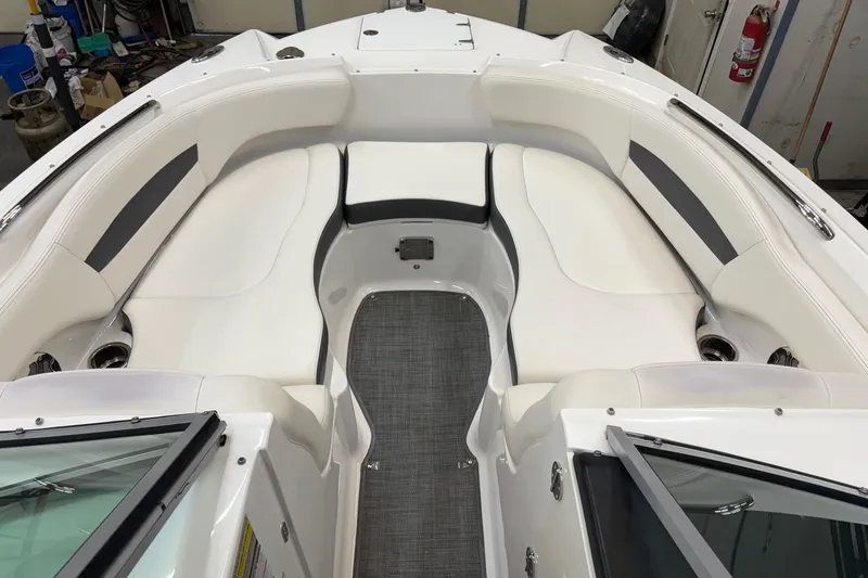 Slide: The Image of 2015 Chaparral 244 Sunesta boat in a garage, showcasing sleek design and spacious deck. - 4