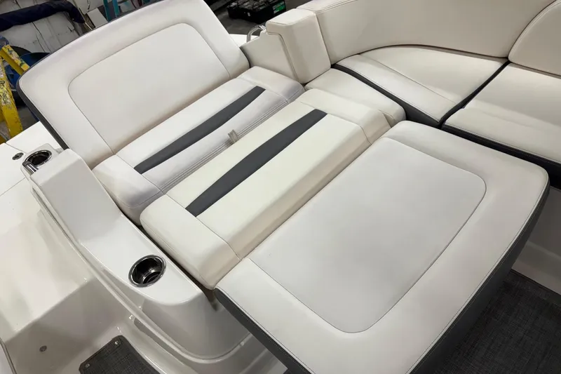 Slide: The Image of 2015 Chaparral 244 Sunesta boat interior with white and gray seating in a workshop. - 7