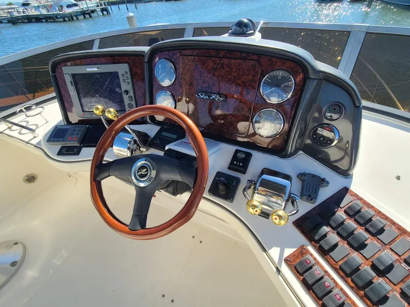 Slide: The Image of 2006 Sea Ray 44 Sedan Bridge helm with wood accents and modern navigation controls. - 13
