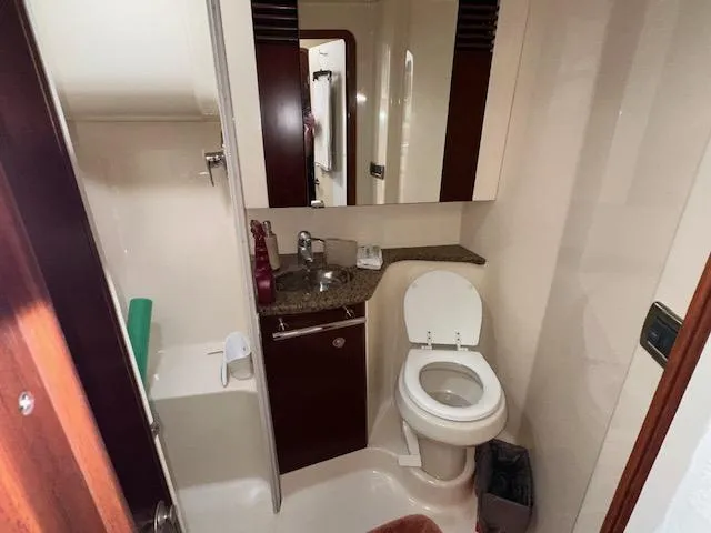 Slide: The Image of 2006 Sea Ray 44 Sedan Bridge bathroom with sink, toilet, and mirror. - 19