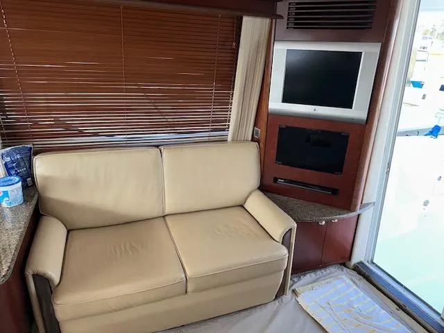 Slide: The Image of Interior of 2006 Sea Ray 44 Sedan Bridge with beige sofa and wall-mounted TV. - 25