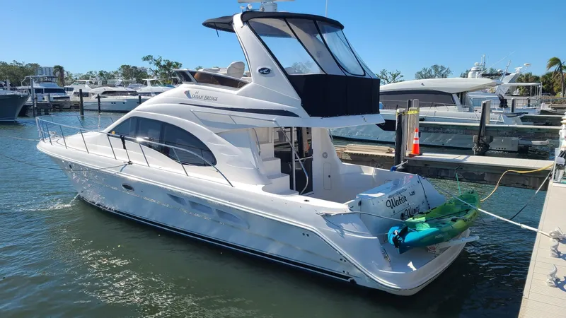 Slide: The Image of 2006 Sea Ray 44 Sedan Bridge yacht docked at marina, featuring sleek design and spacious deck. - 5
