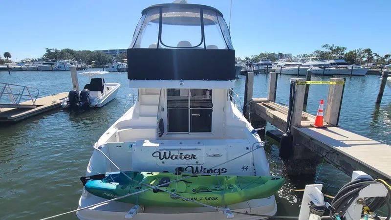 Slide: The Image of 2006 Sea Ray 44 Sedan Bridge docked with kayak, sunny marina background. - 7