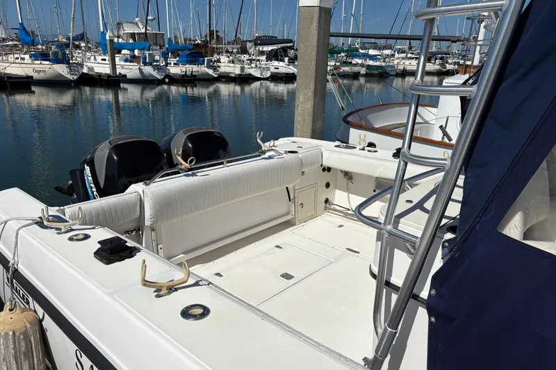 Slide: The Image of 2003 Boston Whaler 290 Outrage docked, featuring dual engines and spacious deck area. - 2