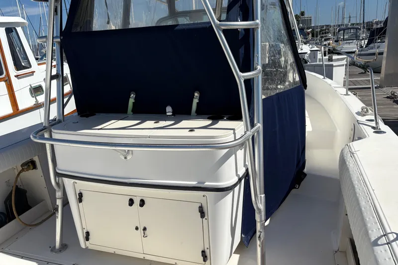 Slide: The Image of 2003 Boston Whaler 290 Outrage boat interior with storage and railing, docked at marina. - 5
