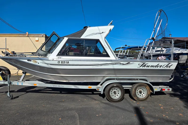 Slide: The Image of 2011 Thunderjet ALEXIS CLASSIC boat on trailer, side view, under clear blue sky. - 21