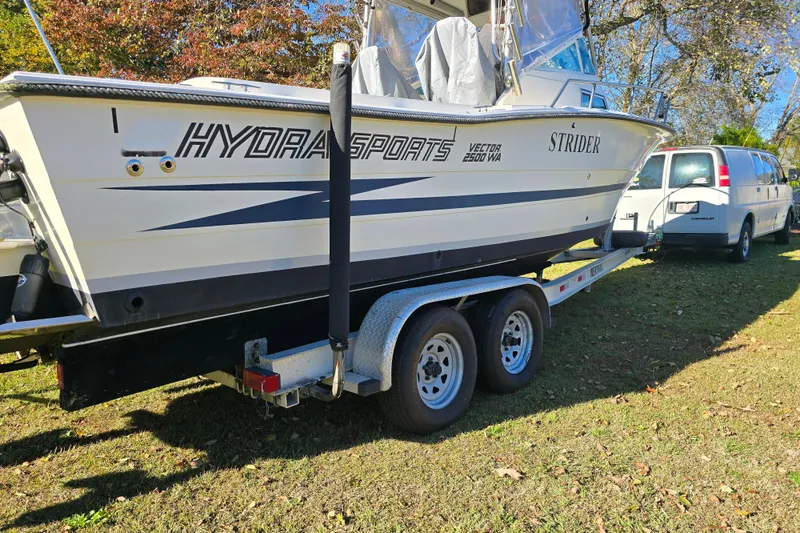 Slide: The Image of 1990 Hydra-Sports 2500WA boat on trailer, parked beside a white van. - 31