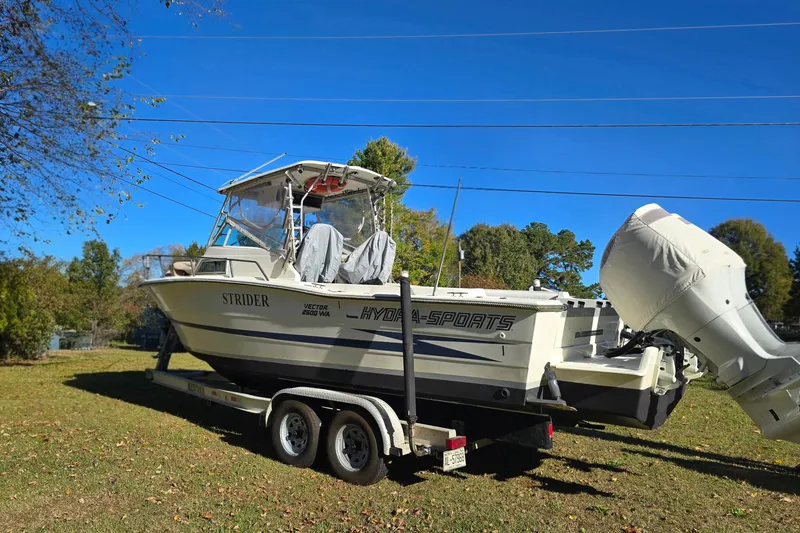 Slide: The Image of 1990 Hydra-Sports 2500WA boat on trailer, parked on grass under clear blue sky. - 7