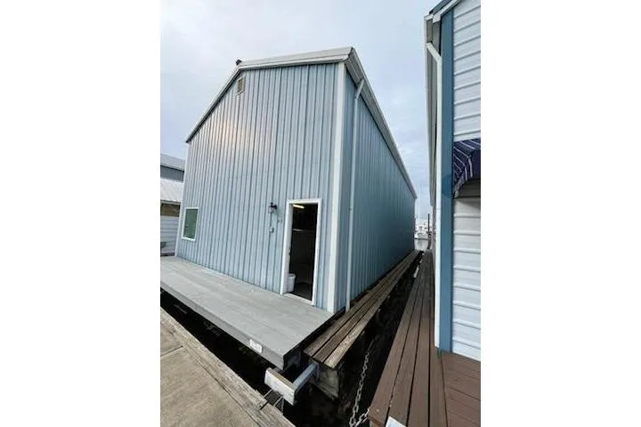 The Image of Custom 1980 boathouse with blue siding and dockside location. - 0