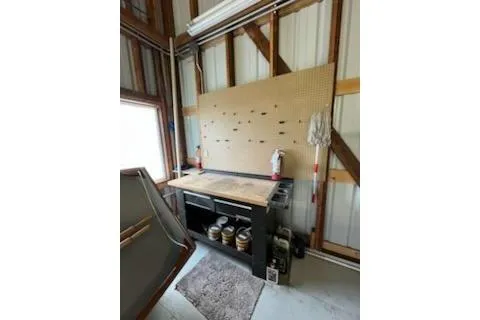 Slide: The Image of Workbench in a 1980 custom boathouse with tools and supplies on a pegboard. - 11