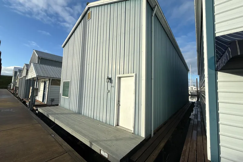 Slide: The Image of Blue custom boathouse from 1980 with dockside view and window. - 2