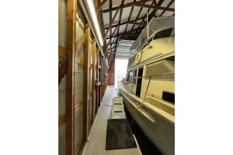 Slide: The Image of 1980 Custom Boathouse interior with docked yacht, wooden beams, and walkway. - 9