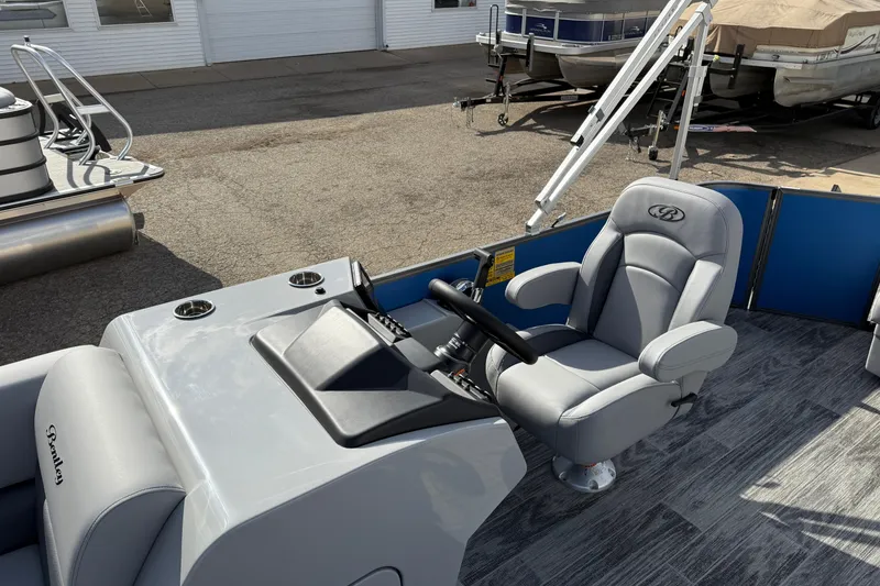 Slide: The Image of 2026 Bentley Pontoons Legacy 223 Cruise XL helm with gray captain's chair and steering wheel. - 16