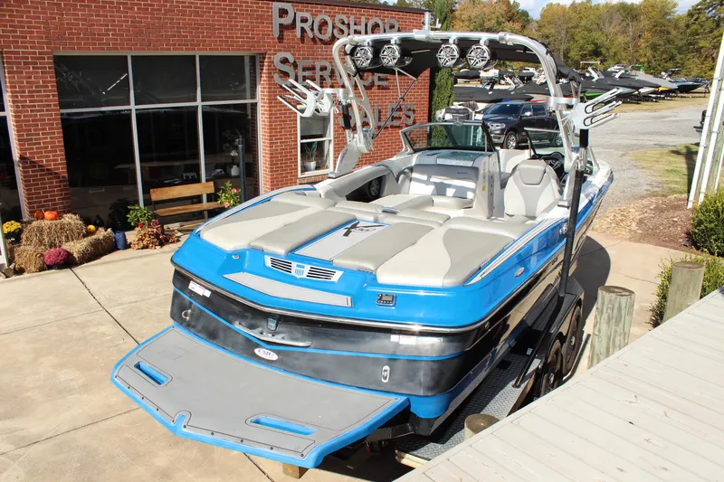 Slide: The Image of 2016 MasterCraft X30 boat with blue and gray design, parked outside a service building. - 4