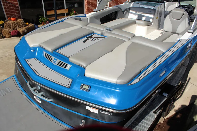 Slide: The Image of 2016 MasterCraft X30 boat with blue and gray seating, displayed outdoors. - 5