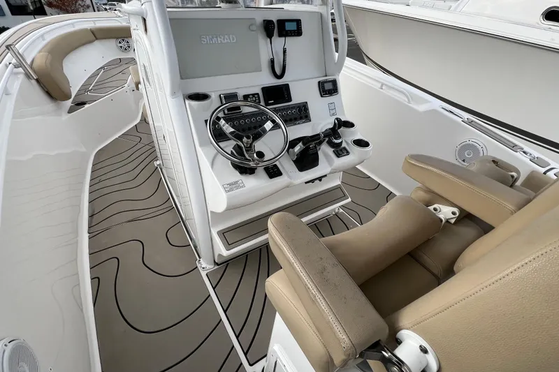 Slide: The Image of 2016 Tidewater 280 CC Adventure boat interior with helm and seating. - 16