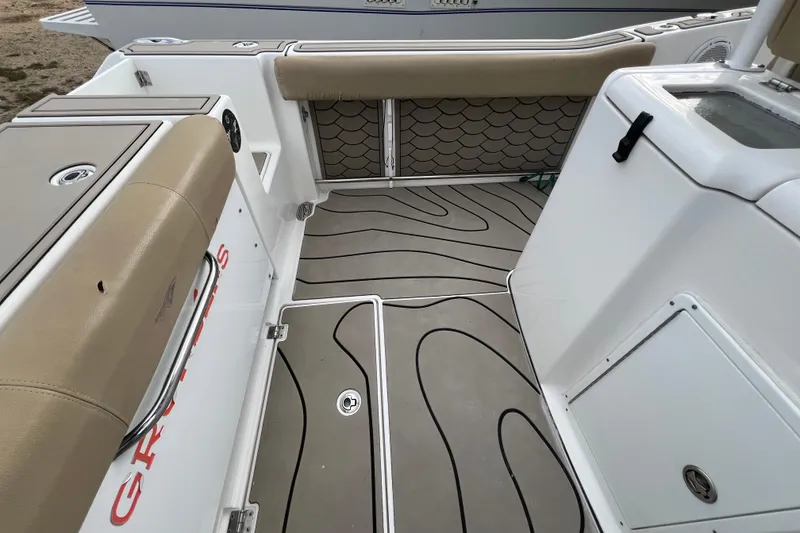 Slide: The Image of 2016 Tidewater 280 CC Adventure boat interior with cushioned seating and patterned flooring. - 30