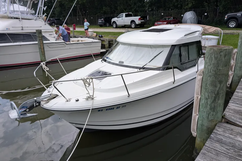 The Image of 2016 Jeanneau Merry Fisher 795 docked at a marina with nearby boats. - 0
