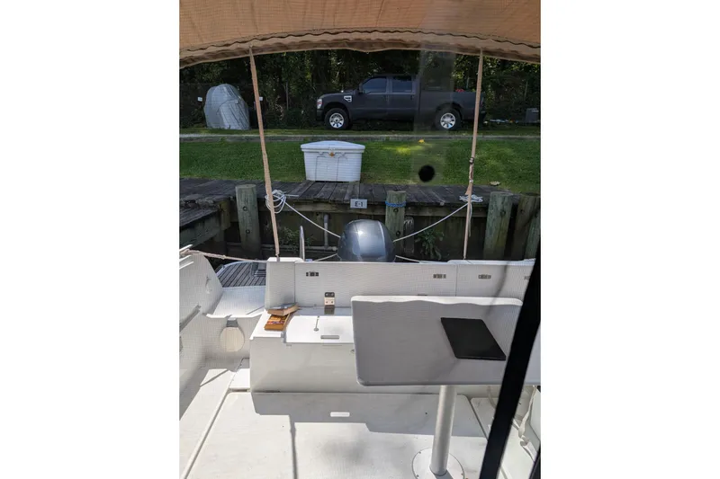 Slide: The Image of 2016 Jeanneau Merry Fisher 795 boat interior with docked view and outdoor seating. - 3