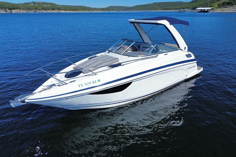 The Image of 2017 Regal 28 Express boat on a serene lake with scenic background. - 0