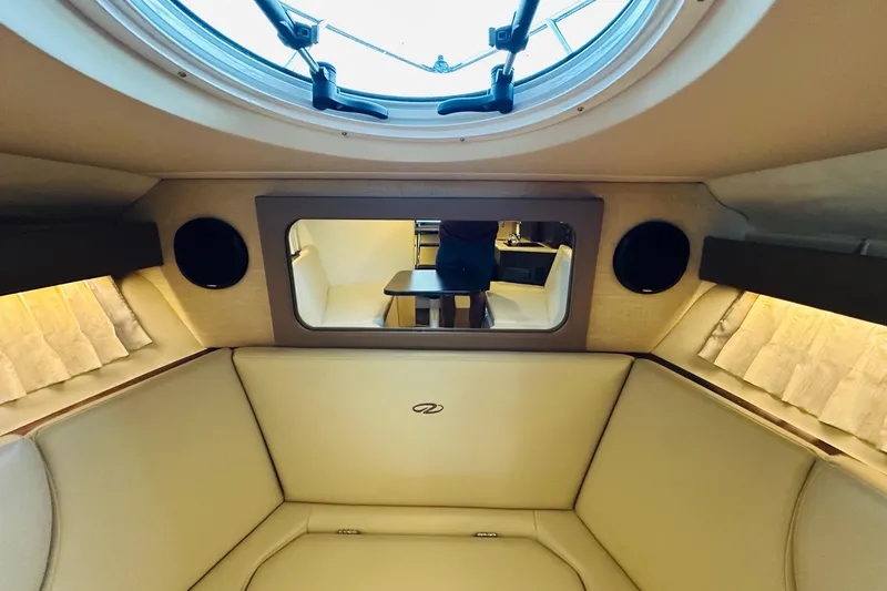 Slide: The Image of Interior of 2017 Regal 28 Express boat with beige seating and round window. - 25