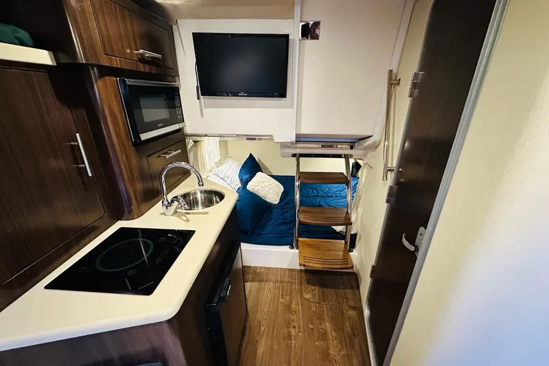 Slide: The Image of 2017 Regal 28 Express interior with kitchenette, TV, and cozy sleeping area. - 27
