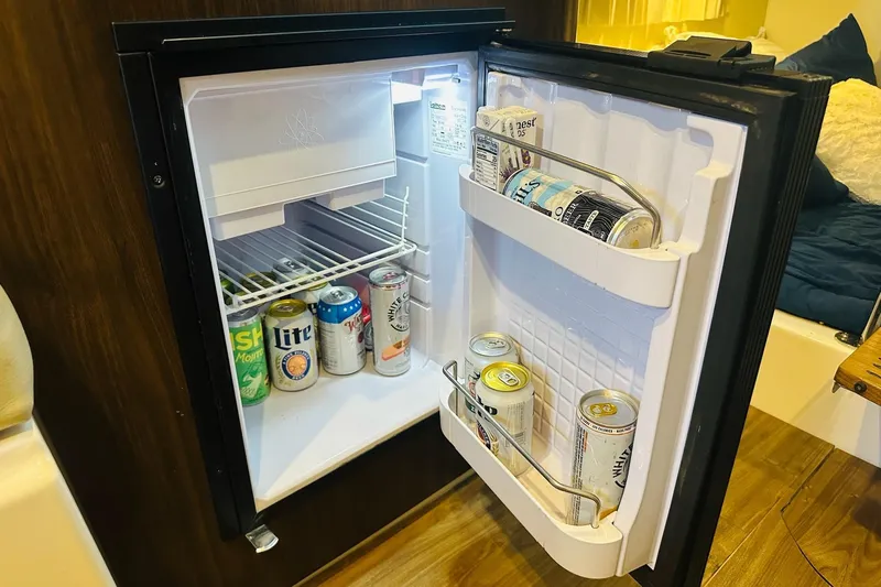 Slide: The Image of Mini fridge stocked with assorted beverages inside a 2017 Regal 28 Express boat. - 30