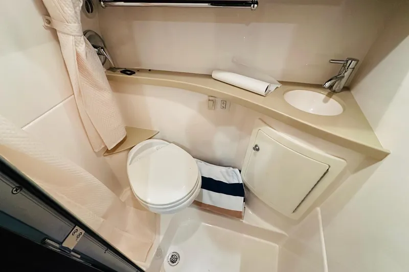 Slide: The Image of 2017 Regal 28 Express boat bathroom with toilet, sink, and shower area. - 32