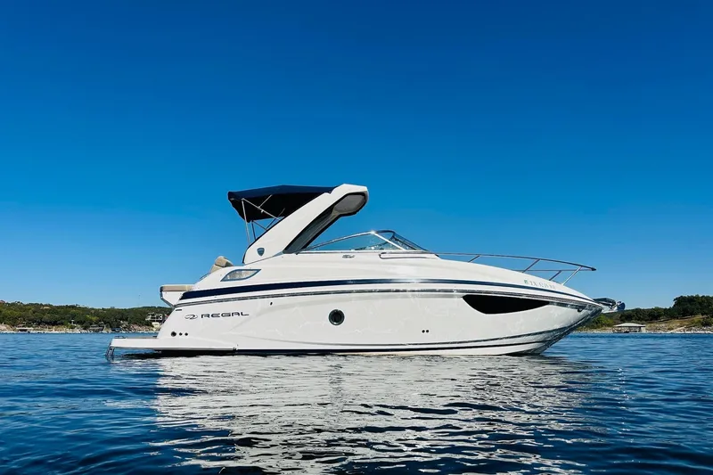 Slide: The Image of 2017 Regal 28 Express boat on calm water under clear blue sky. - 6