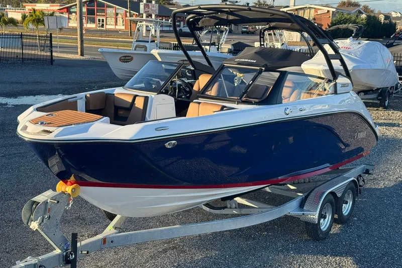 The Image of 2026 Yamaha Boats 222SD on trailer, sleek design, blue and white exterior. - 0