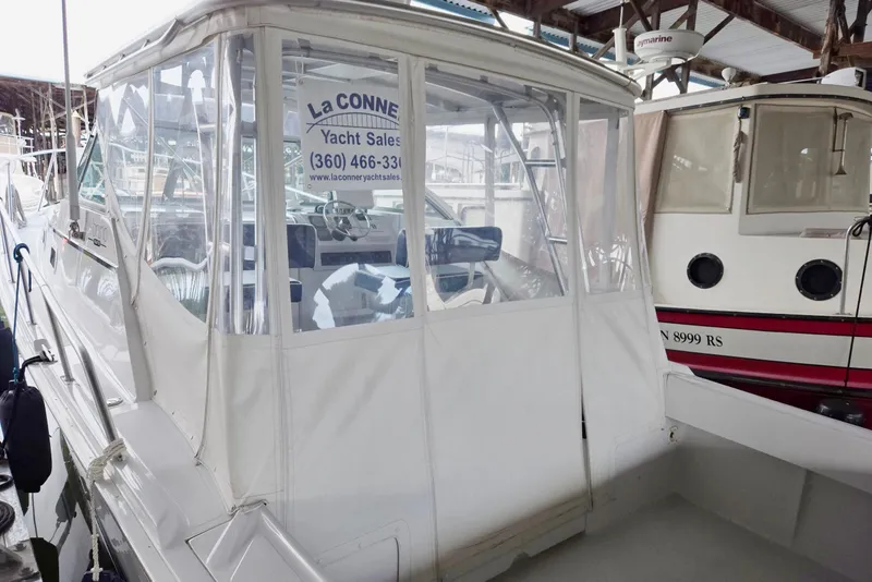 Slide: The Image of 1998 Mainship Pilot 30 yacht docked in marina, covered cockpit, for sale. - 11