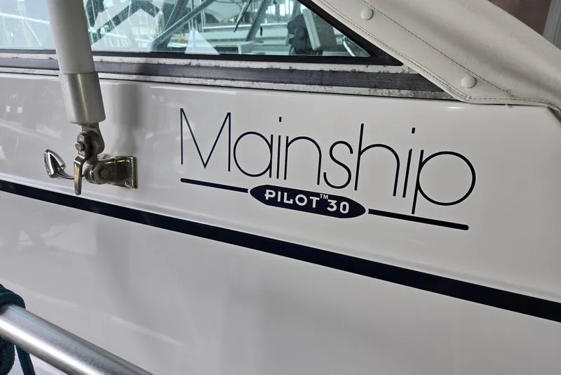 Slide: The Image of 1998 Mainship Pilot 30 boat with logo and window detail. - 13