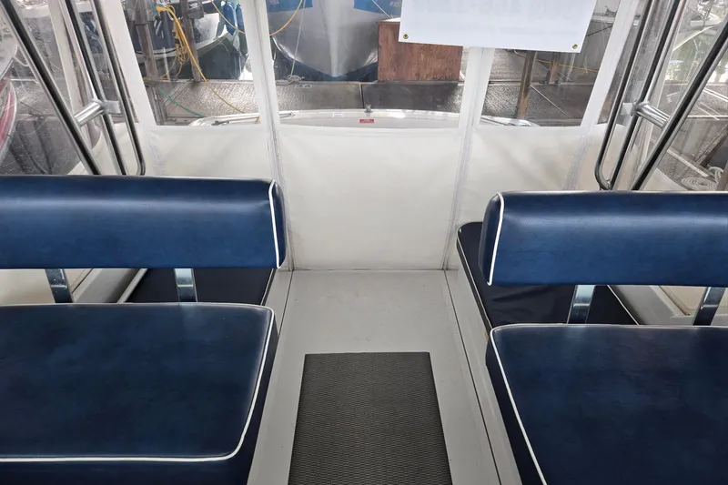 Slide: The Image of Interior of a 1998 Mainship Pilot 30 boat with blue seating and white trim. - 15