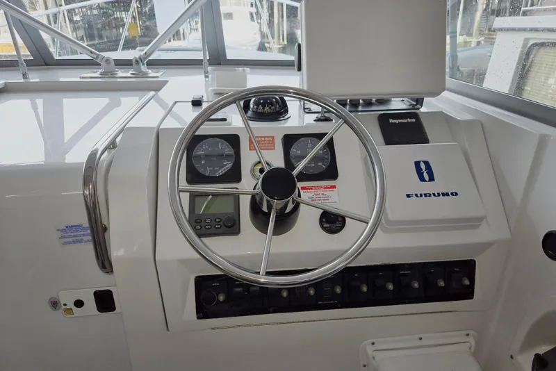 Slide: The Image of 1998 Mainship Pilot 30 helm with steering wheel, gauges, and navigation equipment. - 21