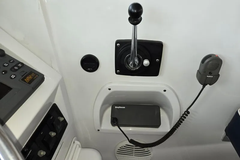 Slide: The Image of 1998 Mainship Pilot 30 helm controls with navigation equipment and communication devices. - 25