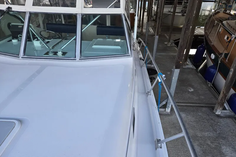 Slide: The Image of 1998 Mainship Pilot 30 boat docked, showcasing deck and cabin windows. - 3